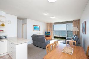 een keuken en een woonkamer met een tafel en een bank bij Oceanic 29 in Forster