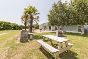 a wooden picnic table sitting in the grass at Saddlers Cottage with indoor pool, tennis court and lots more Tenby area in Saint Florence