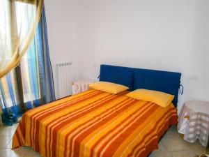 una camera da letto con un letto con una coperta arancione e gialla di Villaggio dei Fiori - Agenzia Cocal a Caorle