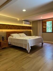 1 dormitorio con 1 cama grande con sábanas blancas en Le Rêve Pousada e Restaurante, en Guaramiranga