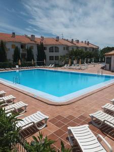 Una piscina con tumbonas y un hotel. en Nora Velha T1, en Tavira