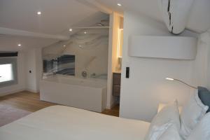 una camera con letto bianco e vasca da bagno di Maison Rascas - Centre historique - Air conditioning- wifi ad Avignone