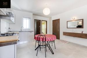 uma cozinha com mesa e cadeiras num quarto em Lovely 2BR home 2 mins away from the promenade by 360 Estates em St. Paul's Bay