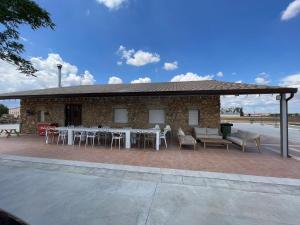 eine Terrasse mit Tischen und Stühlen und ein Gebäude in der Unterkunft Casa Rural Mi Pueblo 