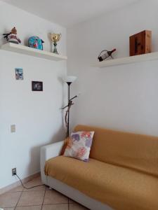 ein Wohnzimmer mit einem Sofa und einem Kissen darauf in der Unterkunft Piccione Marittimo Casa Vacanze in Livorno