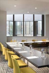 una sala conferenze con un lungo tavolo e sedie gialle di The MC, Autograph Collection a Montclair