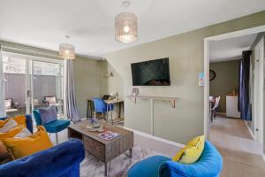 a living room with blue chairs and a table at Stunning 3 bed Abode - Sleeps 7 in Nuneaton