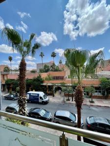 a view of a parking lot with cars and palm trees at Golden house in Marrakesh