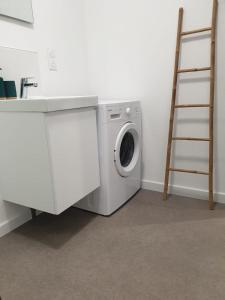 a washing machine in a room with a ladder at Le Jungle in Pamiers +6 photos