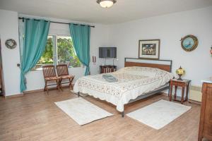 a bedroom with a bed and two chairs and a window at Sweet dreams at the seaside in Skála Foúrkas