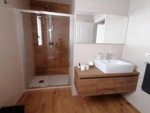 y baño con lavabo blanco y ducha. en Appartamento I Mori, en Cassibile