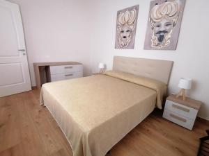 1 dormitorio con 1 cama y 2 cuadros en la pared en Appartamento I Mori, en Cassibile