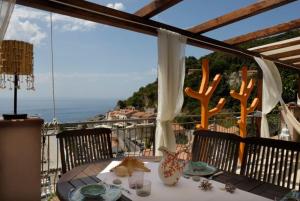 una mesa en un balcón con vistas al océano en COCOSEA: Un attico con vista mozzafiato, en Maratea