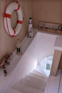 Habitación blanca con un salvavidas rojo y blanco y escaleras en COCOSEA: Un attico con vista mozzafiato, en Maratea
