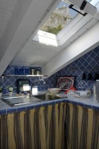 cocina con fregadero y ventana en COCOSEA: Un attico con vista mozzafiato, en Maratea