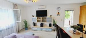 Una sala de estar con una mesa y un televisor en una pared. en Apartments DARIJA & PERO, en Pučišća