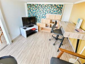 um pequeno escritório com uma secretária e uma televisão num quarto em Le 2neuf - Magnifique T1bis - Grande terrasse em Vertou