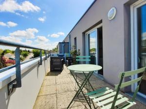 Un patio con una mesa y sillas en un balcón. en Le 2neuf - Magnifique T1bis - Grande terrasse, en Vertou