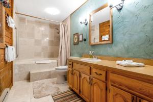 a bathroom with a sink and a toilet and a mirror at The Breck House in Breckenridge +59 photos