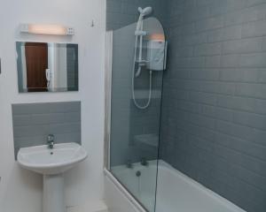 a bathroom with a shower and a sink at Causeway Coast Sea Shore Apartment - Ballycastle in Ballycastle
