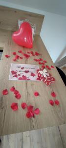 ブローニュ・シュル・メールにあるAcapulco, Superbe souplex proximité vieille villeの赤いバラの花びらを飾ったテーブル +2枚の写真