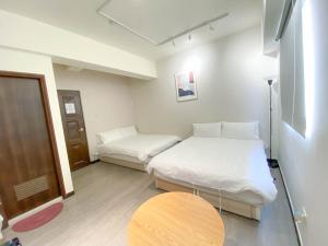 a small room with two beds and a table at 無印旅行 in Taichung