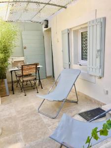 a patio with a chair and a table at Au calme dans le centre avec terrasse et clim in Saint-Rémy-de-Provence
