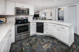 uma cozinha com armários brancos e um fogão em Nautilus 2510 Gulf View 2 Bedroom 5th Floor Free Beach Service em Fort Walton Beach