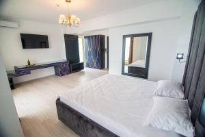 - une chambre avec un grand lit et une télévision dans l'établissement Alessio Hotel Residence, à Costinesti