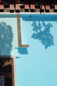 riflessione di una piscina con sedie di Hotel Friuli a Lignano Sabbiadoro