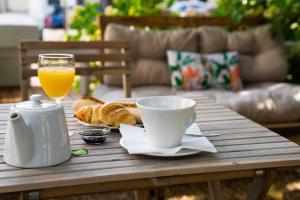 una mesa de centro con un vaso de zumo de naranja y cruasanes en Hôtel VAL FLORES LOGIS, en Biarritz