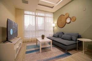 a living room with a couch and a flat screen tv at 46 Serviced Apartments in Amman