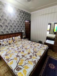 a bedroom with a bed with a yellow and white blanket at Sukh Sagar Hotel in Jaipur