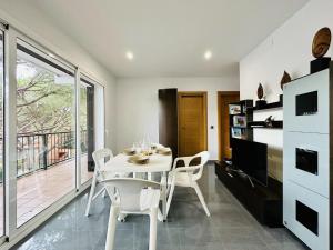 a white dining room with a white table and chairs at Paradis CostaBravaSi in Platja d'Aro