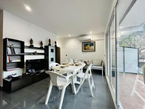a dining room with a white table and chairs at Paradis CostaBravaSi in Platja d'Aro +18 photos
