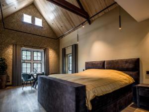 een slaapkamer met een groot bed en een houten plafond bij Lindenhuys Logies in Sint-Oedenrode