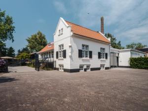 uma grande casa branca com uma entrada de tijolos em Lindenhuys Logies em Sint-Oedenrode