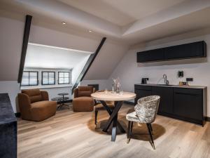 een keuken en een woonkamer met een tafel en stoelen bij Lindenhuys Logies in Sint-Oedenrode