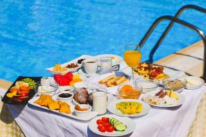 a table with food and drinks next to a pool at Rapos Resort Hotel in Himare