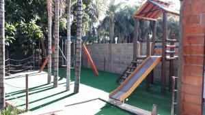 a playground with a slide and some trees at Pousada Recanto Solar dos Pássaros in Olímpia