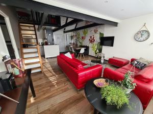 a living room with a red couch and a table at Belle - Mooi Zuid Limburg in Simpelveld