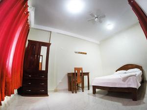 ein Schlafzimmer mit einem Bett, einer Kommode und einem Tisch in der Unterkunft Bello-Oriente-II in Iquitos