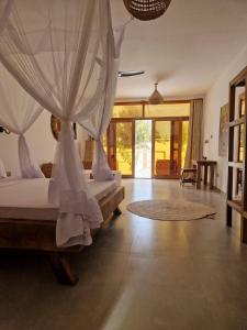 a bedroom with a bed with a mosquito net at Sunny Villa Matemwe in Matemwe