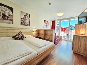 a bedroom with a large bed and a large window at Familienhotel Trebesingerhof in Trebesing