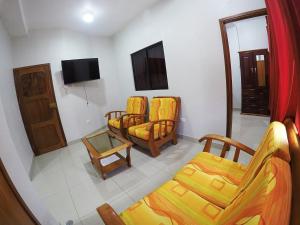 ein Wohnzimmer mit 3 Stühlen und einem TV in der Unterkunft Bello-Oriente-II in Iquitos