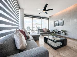 sala de estar con sofá y mesa en DC 1103 Trendy Condo in Mamitas beach area half block to 5th, en Playa del Carmen