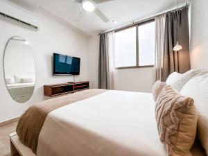 1 dormitorio con 1 cama grande y espejo en DC 1103 Trendy Condo in Mamitas beach area half block to 5th, en Playa del Carmen