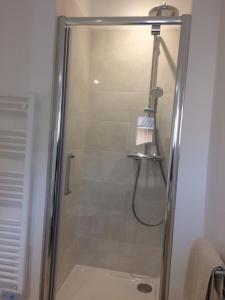 una doccia con porta in vetro in bagno di Au calme dans le centre avec terrasse et clim a Saint-Rémy-de-Provence