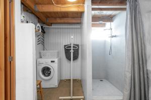 een wasmachine en droger in een kleine badkamer bij Vibrant 1BR Home in Reykjavik in Reykjavík