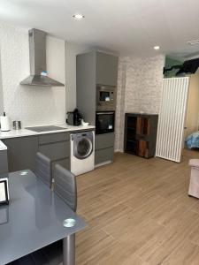 uma cozinha e sala de estar com uma mesa e uma máquina de lavar louça em Apartamentos Aguacate em Madri